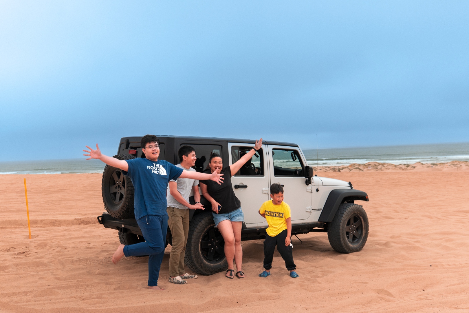 Family with Jeep Wrangler on the beach